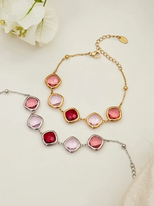 Detail of gold and silver stainless steel bracelets with square cut pink crystal stones