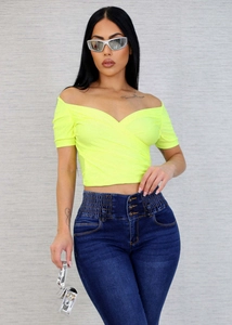 Detail of high waist dark blue jeans with three buttons and neon yellow cropped top