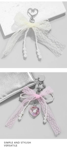 Detailed view of pink and white lace bow keychains with pearls and heart pendants