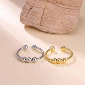 Detail of adjustable gold and silver spinner rings with sliding beads for anxiety relief