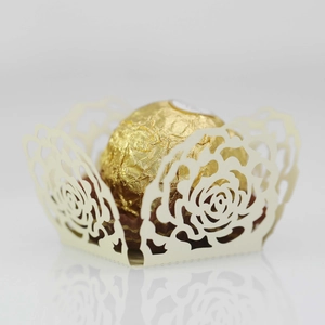 Macro shot of laser-cut rose pattern on beige paper candy wrapper for wedding party