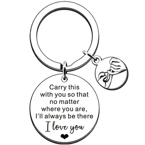 Detailed macro view of engraved silver stainless steel key ring with heart and pinky swear