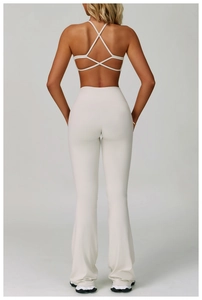Back view of white flare yoga pants and criss-cross back sports bra on model