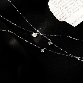 Close-up of three elegant silver necklaces with sparkling round zircon pendants