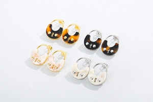 Detail of lock-shaped earrings in tortoiseshell and marble resin with gold accents
