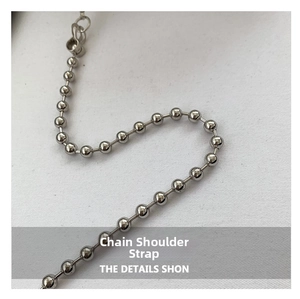 Detailed macro shot of a shiny silver beaded metal shoulder strap with lobster clasp