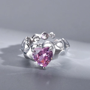 Macro detail of irregular silver ring featuring a large pink heart-shaped gemstone inlay