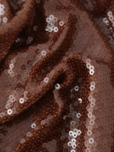 Macro shot of brown sequin fabric with shimmering mesh texture on an elegant dress