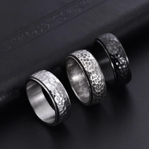 Detailed macro shot of three rotating honeycomb hammered steel rings in silver and black
