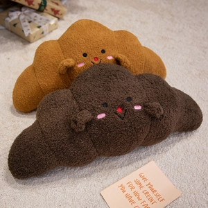 Cute croissant plush pillows in light and dark brown fleece with soft facial expressions