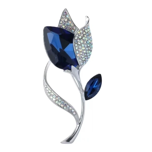 Elegant silver flower brooch with deep blue crystals and rhinestones on white background