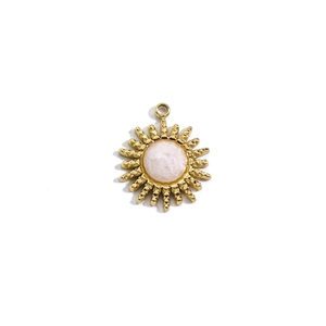 Detailed view of sun-shaped 14K gold plated pendant with central pink crystal gemstone