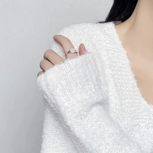 Detailed view of an S925 silver ring with a white oval opal on a soft sweater background