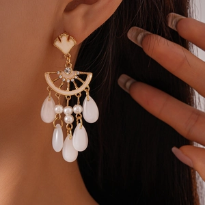Détail macro de boucles d'oreilles feuille de ginkgo avec perles et cristaux brillants