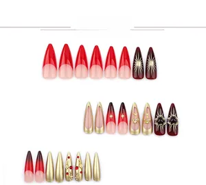 Close-up of red almond press-on nails featuring golden stars and heart nail art charms