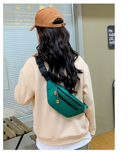 Detail showing the green oxford fabric texture and adjustable strap of the waist bag
