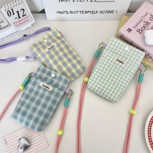 Detailed view of three checkered canvas mini bags in yellow, mint, and blue-grey tones