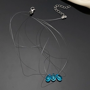 Close-up of invisible fish line necklace with three blue teardrop zircon crystal pendants