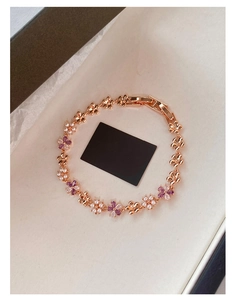 Detail of rose gold flower bracelet featuring purple marquise zircons and white pearls