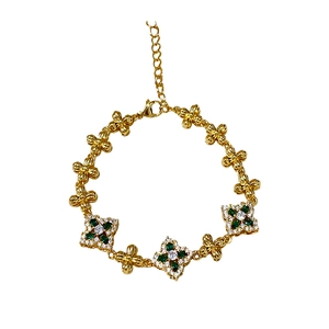 Pulsera vintage dorada con piedras verdes y colgantes de trébol de circonita