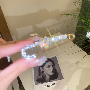 Close-up of safety pin brooch with shimmering crystals and elegant pearl fringe detail