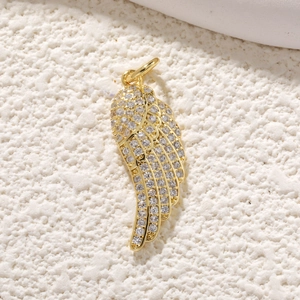 Vue macro d'un pendentif aile d'ange doré avec détails scintillants en pavé cristal