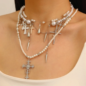 Close-up of multilayer pearl necklace with silver cross and rhinestone drop pendants