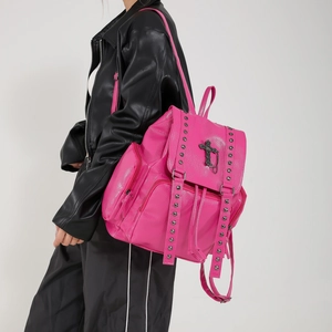Pink PU leather backpack with silver rivets and gothic cross accents worn by model