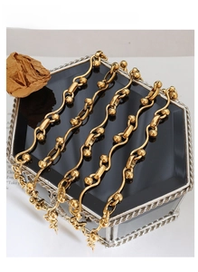 Close-up of a gold-plated chunky link necklace on a mirrored jewelry box with rose