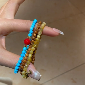 Détail de bracelets en perles turquoise avec accents dorés et pierres précieuses