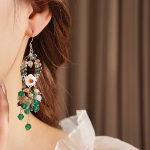 Boho Quastenohrringe mit Muschelmotiven und Perlen getragen von einem Modell