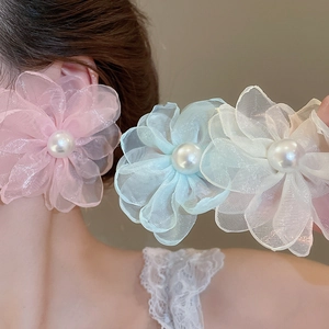 Detailed close-up of chiffon flower earrings with pearls in pink, blue and white colors