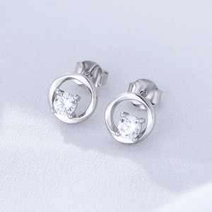 Macro shot of silver geometric hollow round earrings with sparkling cubic zirconia stone
