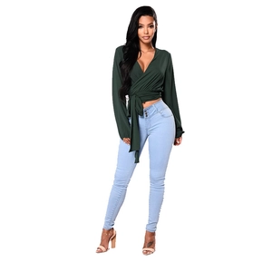 Haut cache-cœur vert à manches longues et col en V avec un jean skinny bleu clair cintré