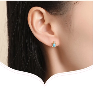 Detailed close-up of a turtle-shaped silver stud earring featuring zircon and blue stone