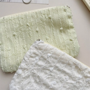 Detail of floral chiffon mini pouches with 3D embroidery and metal zipper closure