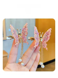 Close-up of moving butterfly hair clips with pink crystals and gold pearl tassels