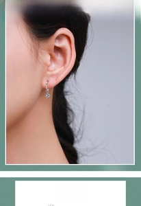 Macro detail of a 925 sterling silver hoop earring with sparkling zircon on a model