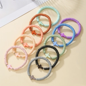 Detailed array of colorful bohemian polymer clay beaded bracelets with cross charms
