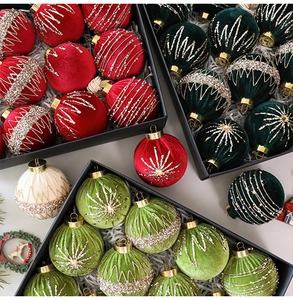 Close-up of velvet Christmas balls with glitter patterns in a black luxury gift box