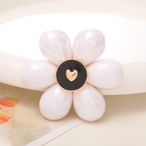 Detailed macro view of white pearl flower accessory with gold heart center detail