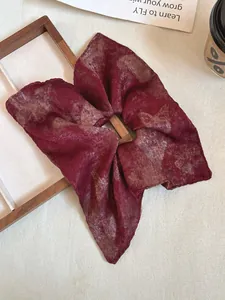 Macro detail of wine red square hair scrunchie with vintage texture and satin sheen