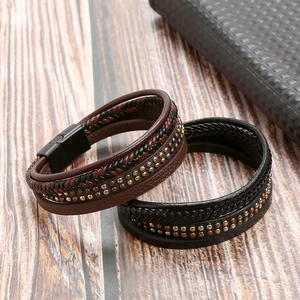 Men's fashion braided leather bracelet with metal studs and magnetic clasp on wood