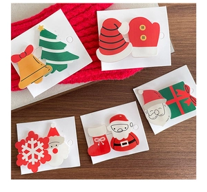 Close-up of cute Santa and Christmas tree hair clips on festive red knit background