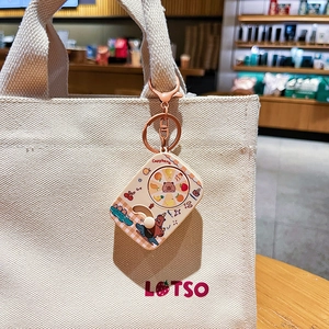 Cute rotating Capybara keychain accessory with cartoon graphics on a beige canvas tote bag
