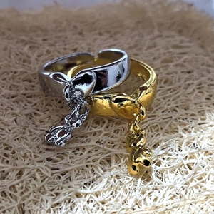 Detailed macro view of open adjustable bear rings in gold and silver finishes