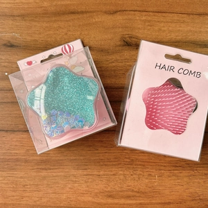Detailed view of pink and mint star-shaped hair combs in cute illustrated packaging