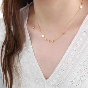 Elegant gold titanium steel necklace with star pendants and fringe chain on a model