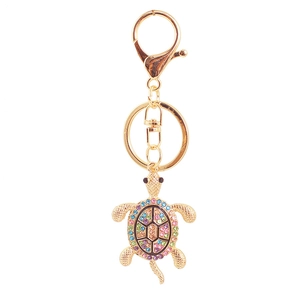 Dettaglio di un portachiavi a tartaruga dorata con strass colorati e moschettone