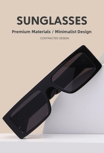 Detail of oversized black rectangle sunglasses with sleek glossy frames and dark lenses